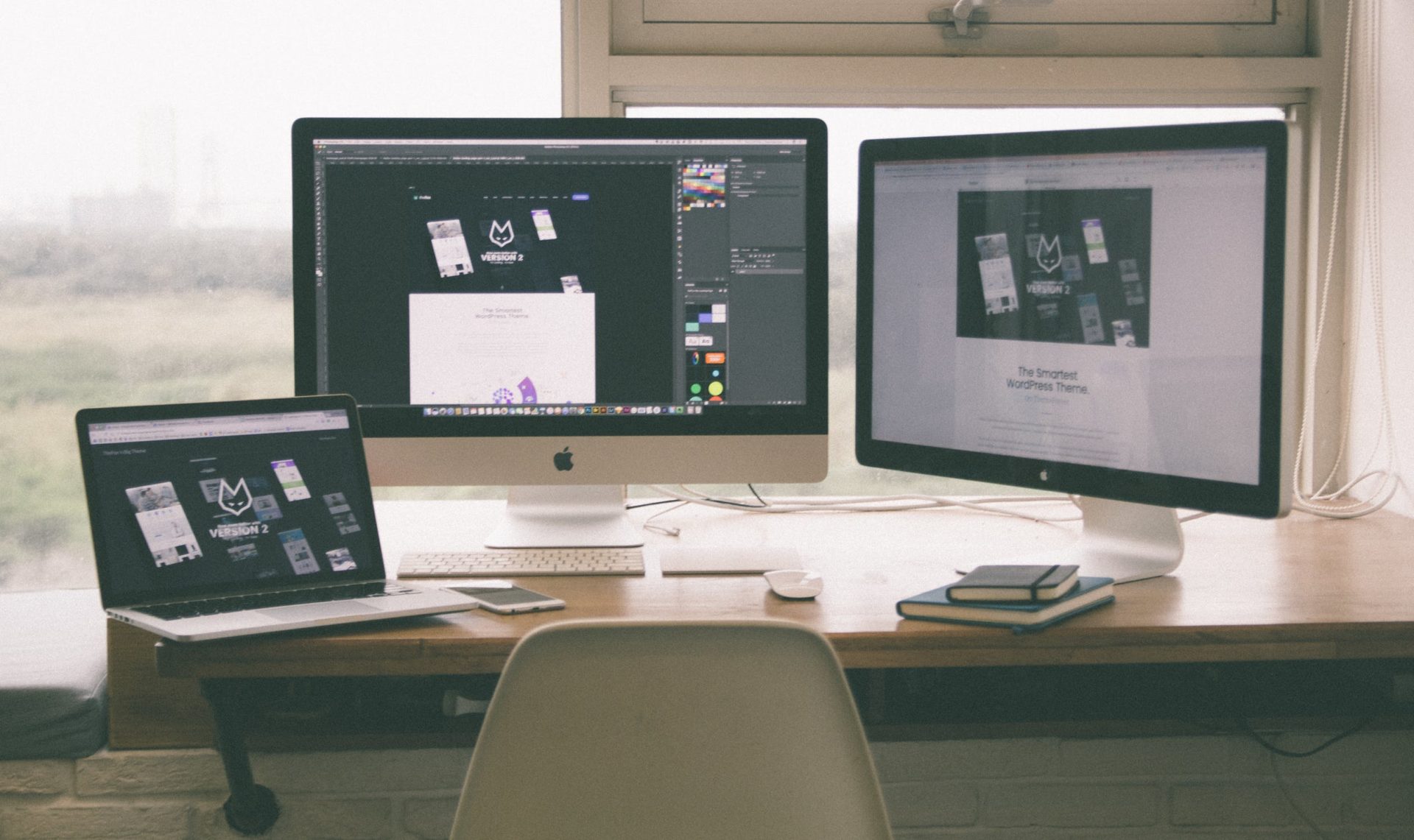 Two computer screens and a laptop on a desk